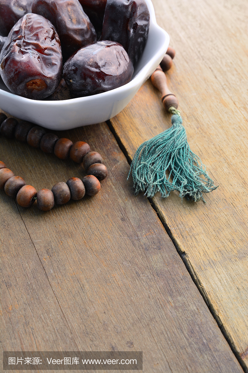 Dates fruit and prayer beads still life, on wooden background